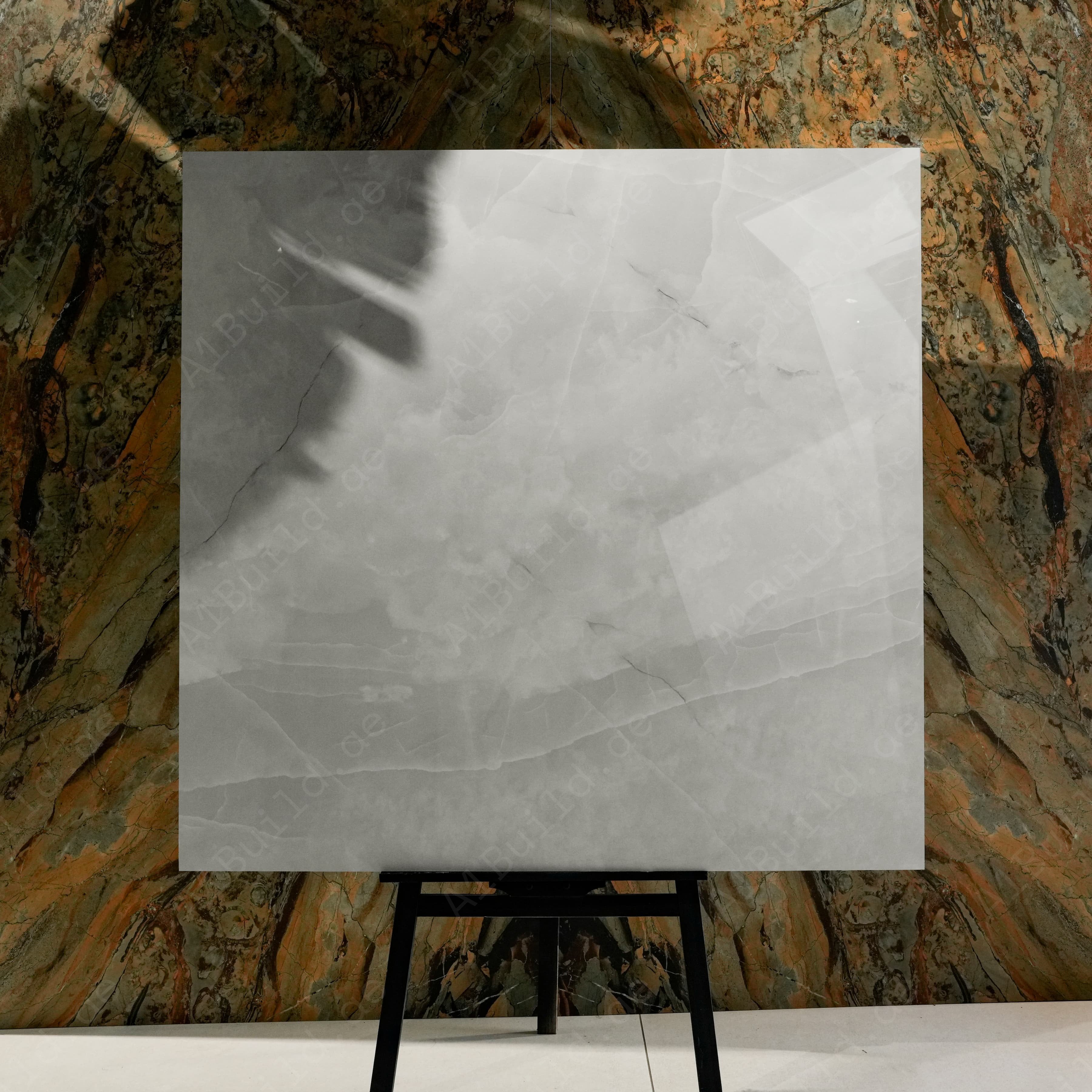 Onyx Lural Glossy 120x120 porcelain tile displayed on easel against natural marble backdrop in UAE showroom