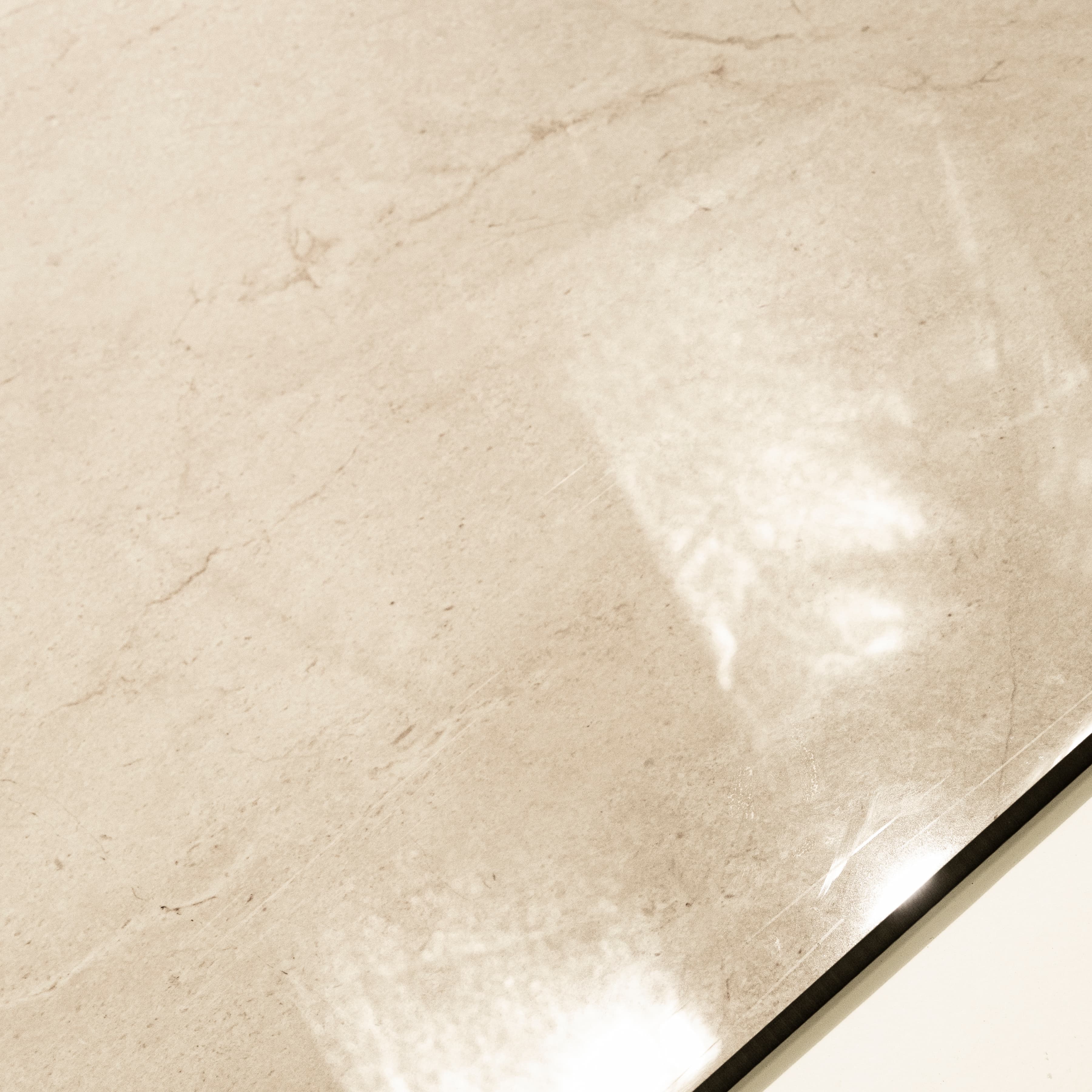 Close-up detail showing the soft veining and mirror-gloss finish of Marfil Pearl porcelain tile