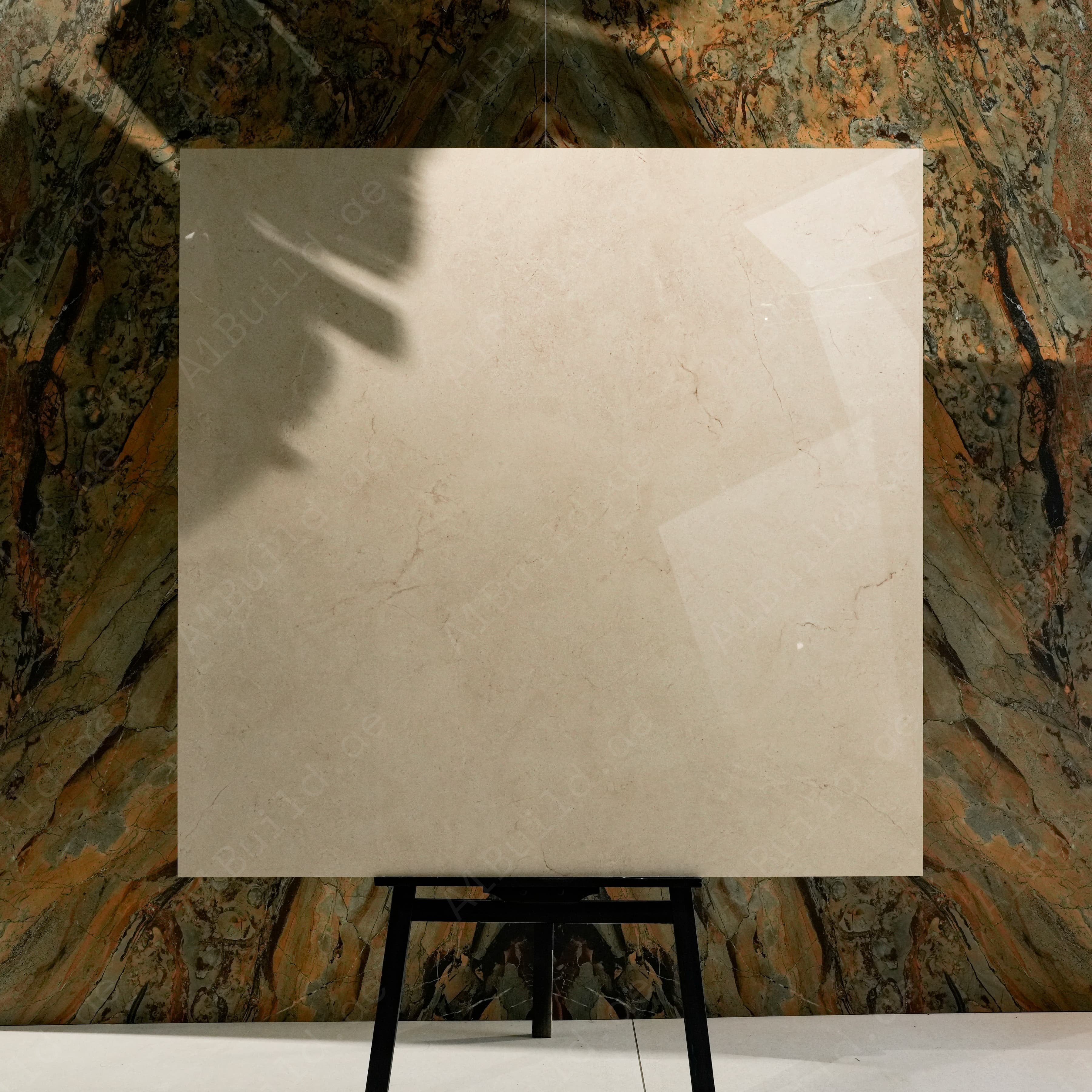 Marfil Pearl Glossy 120x120 porcelain tile displayed on easel against natural marble backdrop in UAE showroom