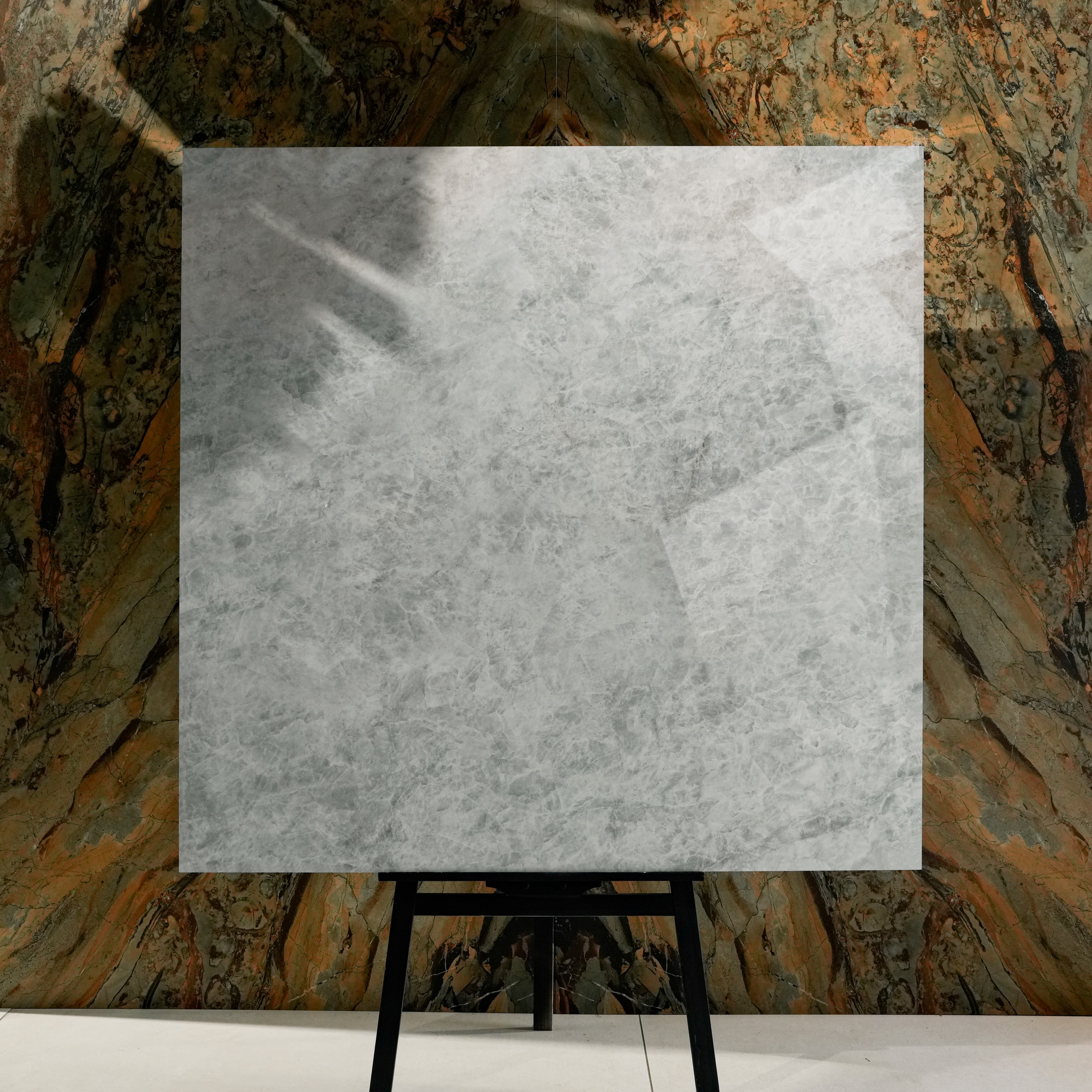 Celest Onyx Glossy 120x120 porcelain tile displayed on easel against natural marble backdrop in UAE showroom
