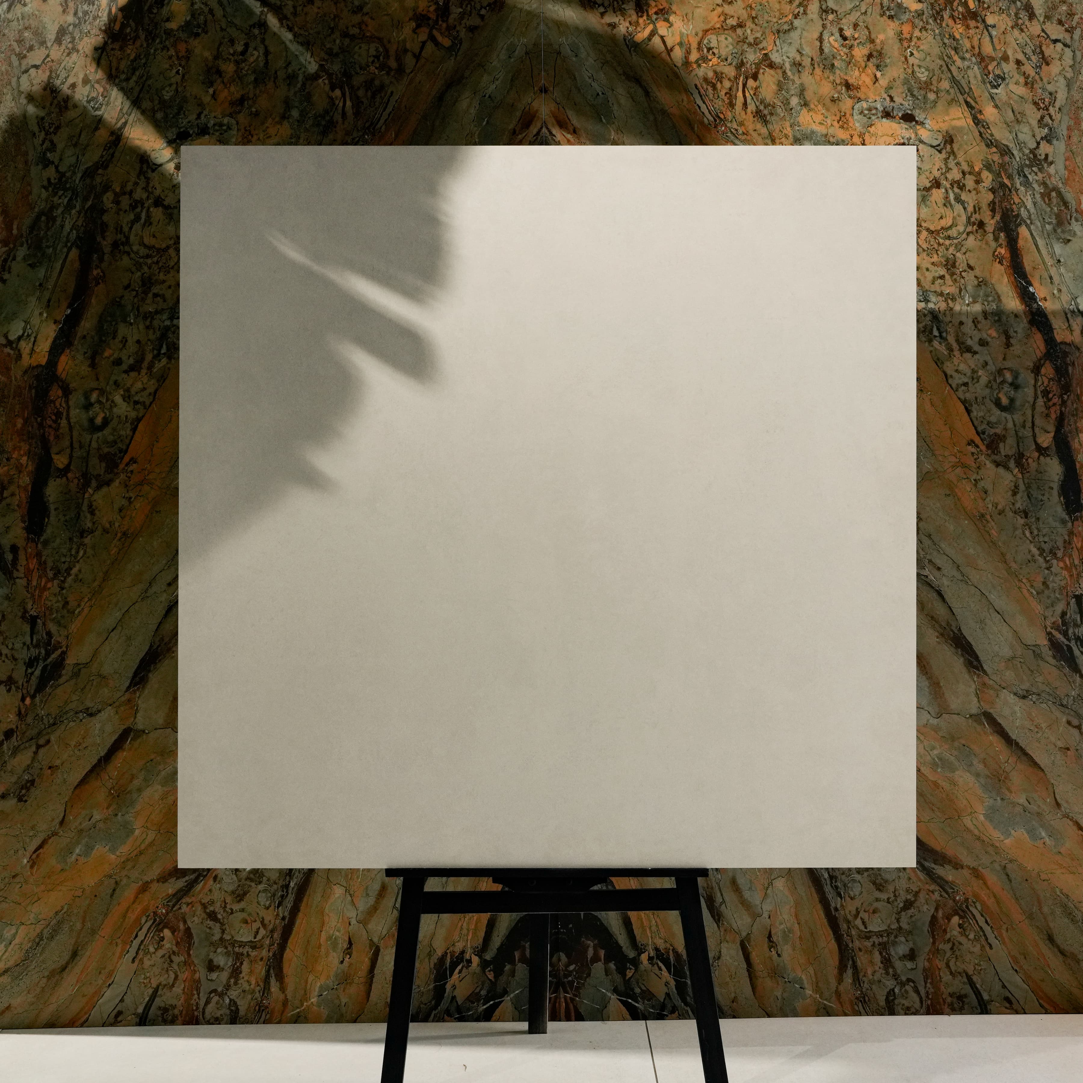 Polo White 120x120cm classic refined white matte porcelain tile on easel against onyx marble backdrop in UAE luxury tile showroom