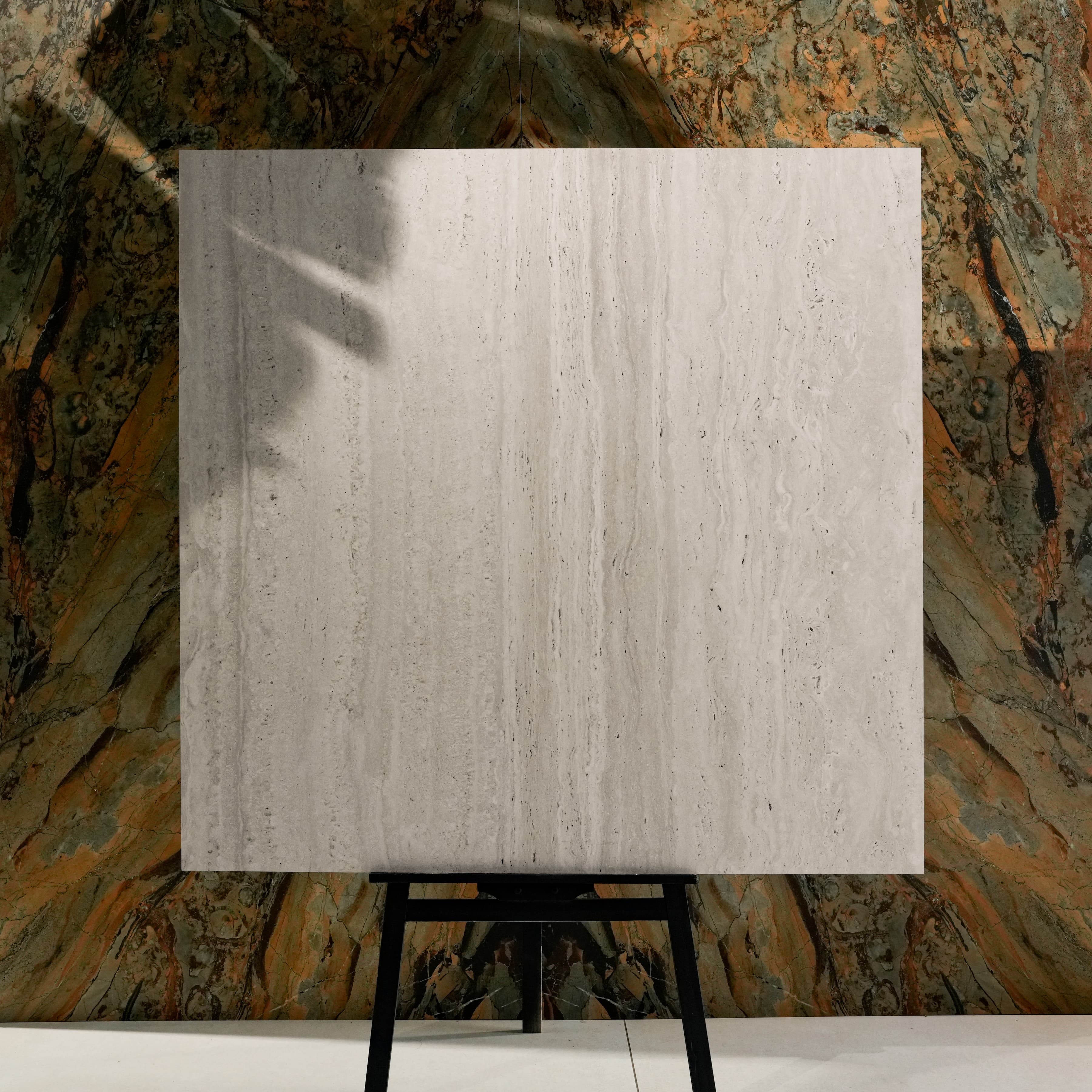 Roma Travertino Bianco 120x120cm Italian vein-cut travertine effect matte porcelain tile on easel against onyx marble backdrop in UAE luxury tile showroom