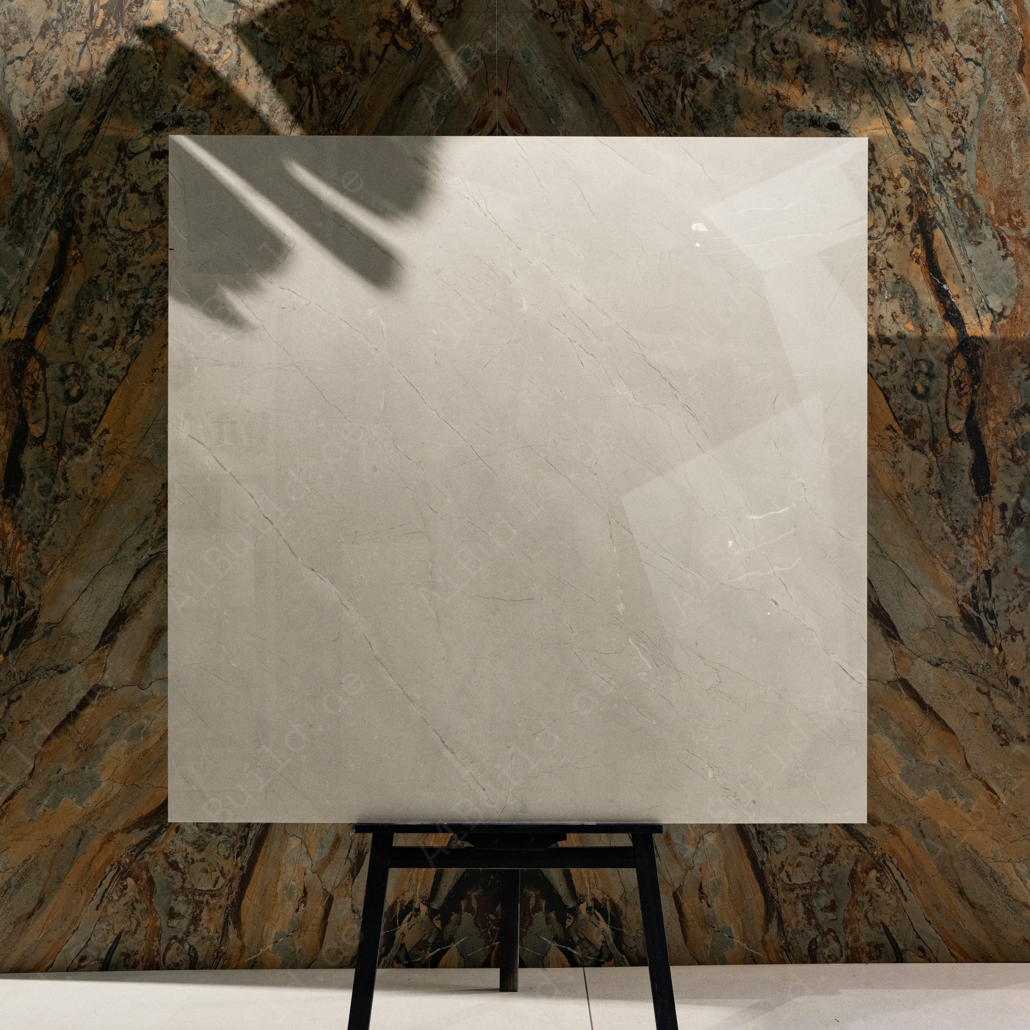 Burberry Bianco 120x120cm British heritage cream marble look high-gloss polished porcelain tile on easel against onyx marble backdrop in UAE luxury tile showroom