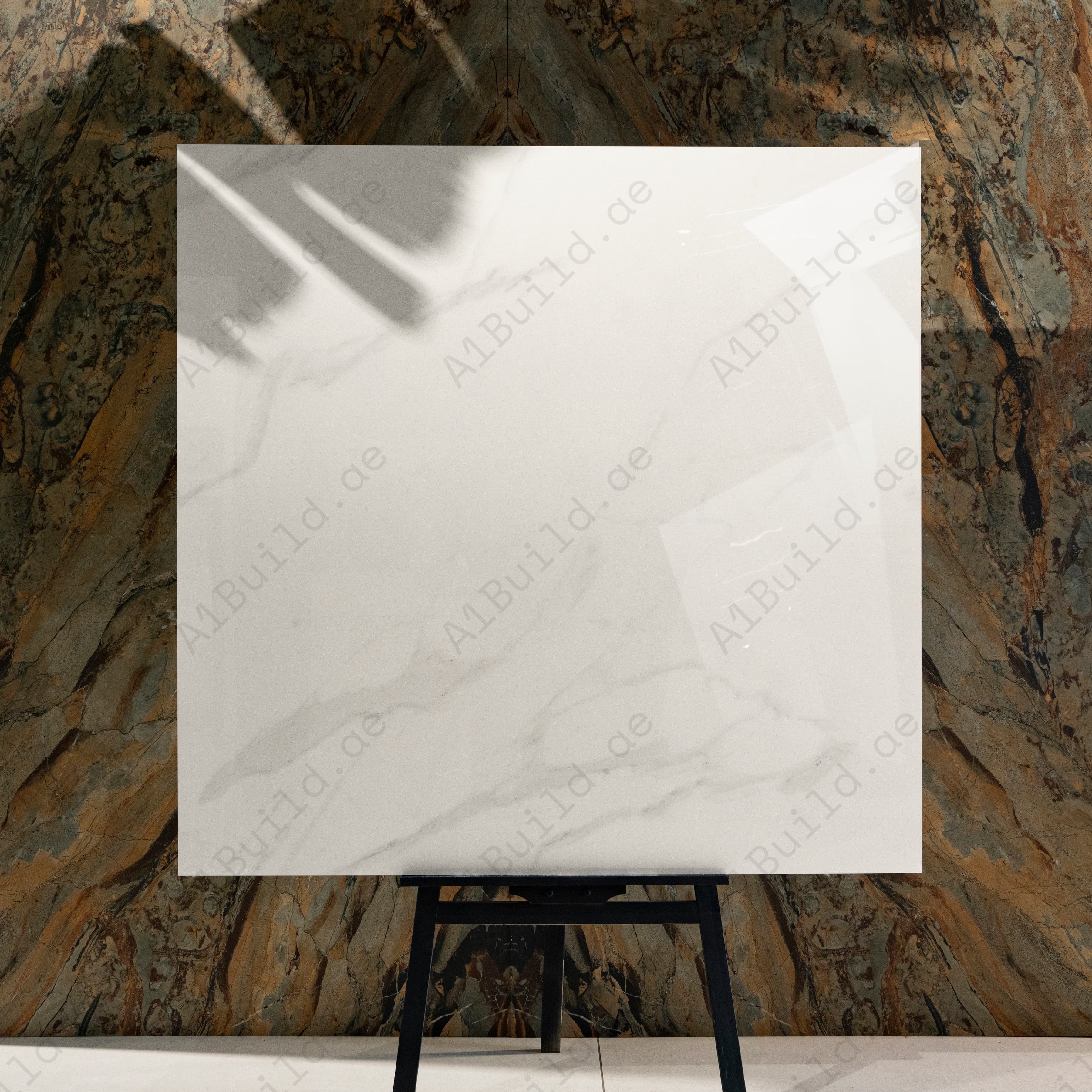 Elite White 120x120cm pure bright white marble look glossy polished porcelain tile on easel against onyx backdrop in UAE luxury tile showroom