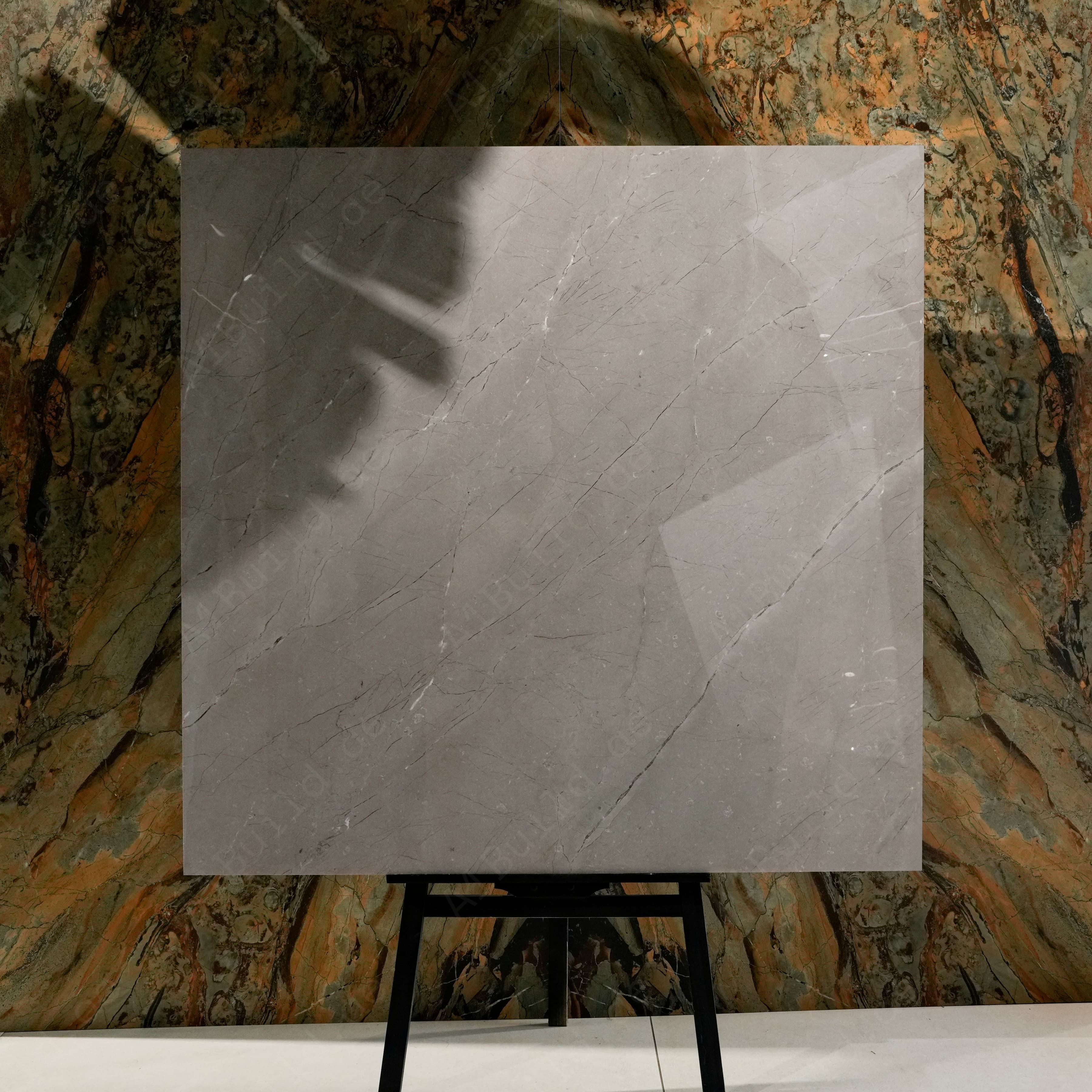 Burberry Grey Glossy 120x120 porcelain tile on easel display against natural marble backdrop in UAE showroom