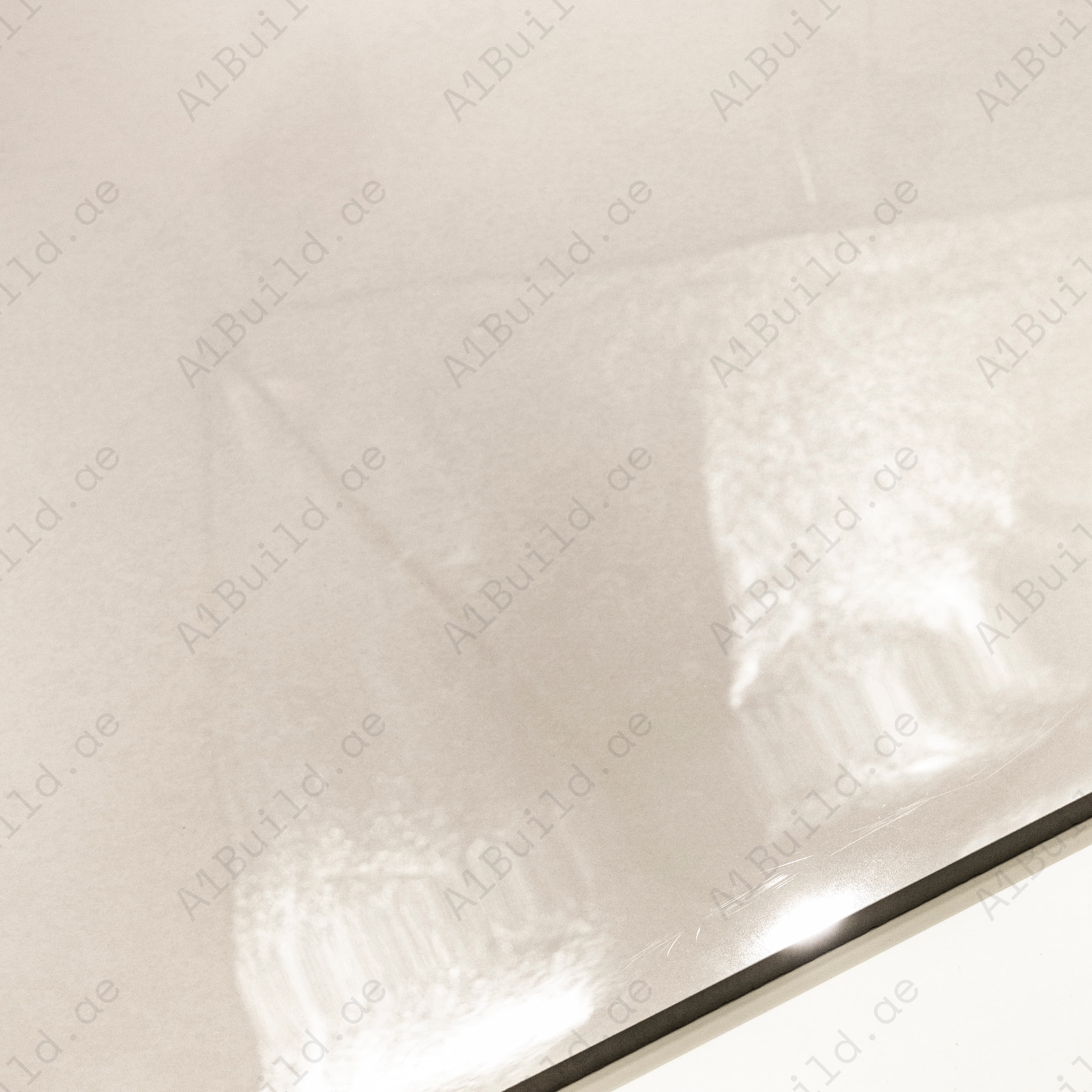 Close-up of Portland Bianco glossy porcelain tile showing mirror-polished cream surface and 9mm thickness