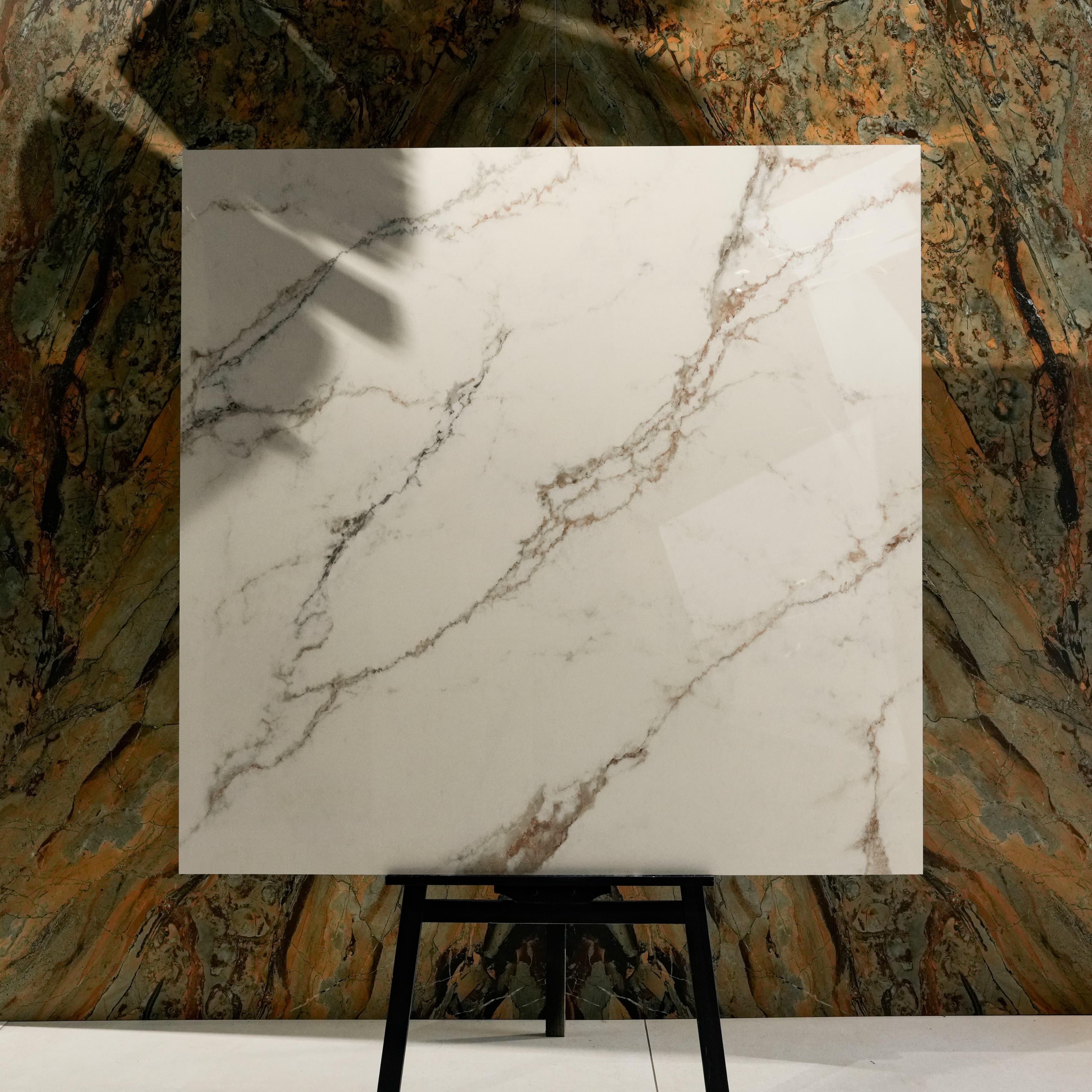 Signora Glossy 120x120 porcelain tile displayed on easel against natural marble backdrop in UAE showroom