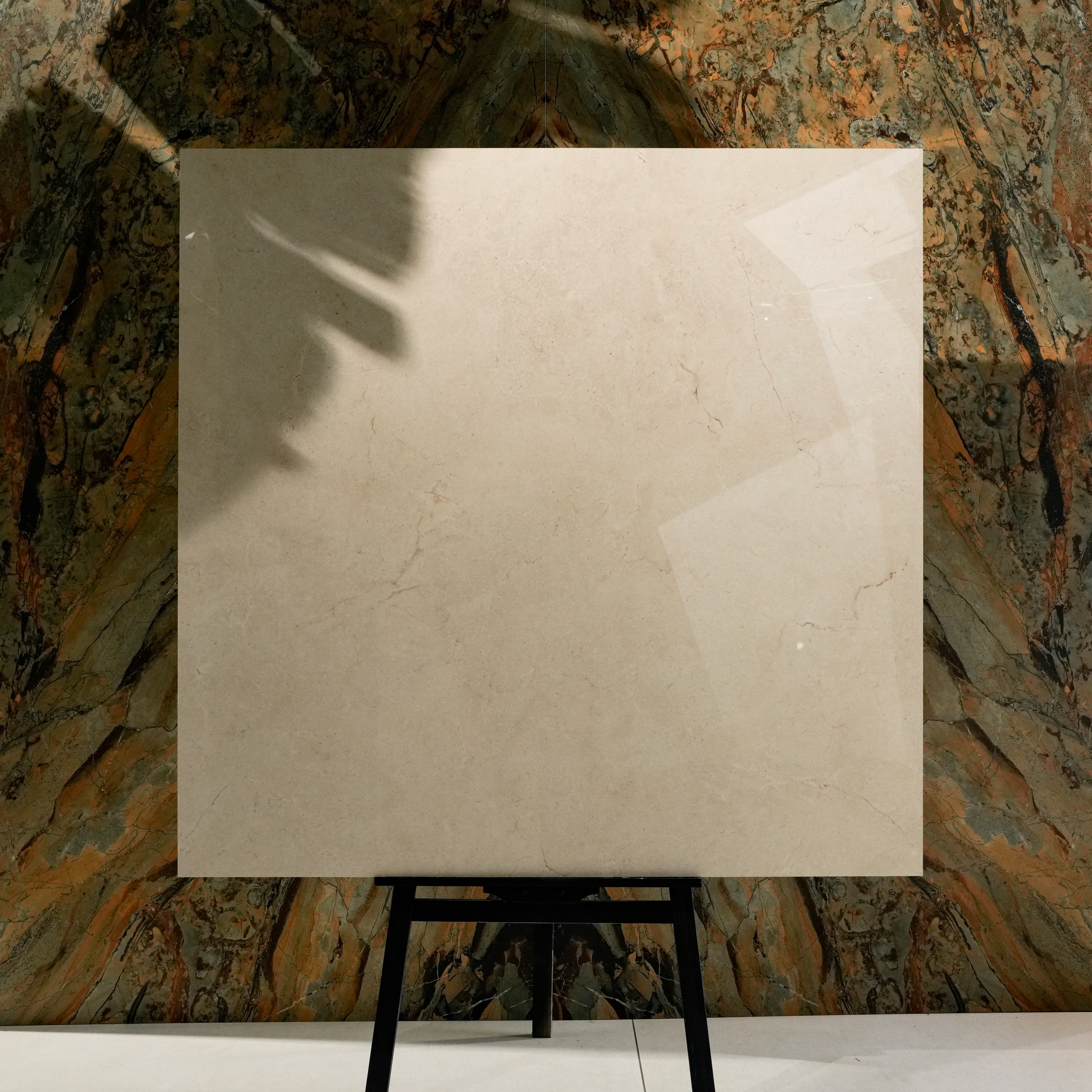 Marfil Pearl Glossy 120x120 porcelain tile displayed on easel against natural marble backdrop in UAE showroom
