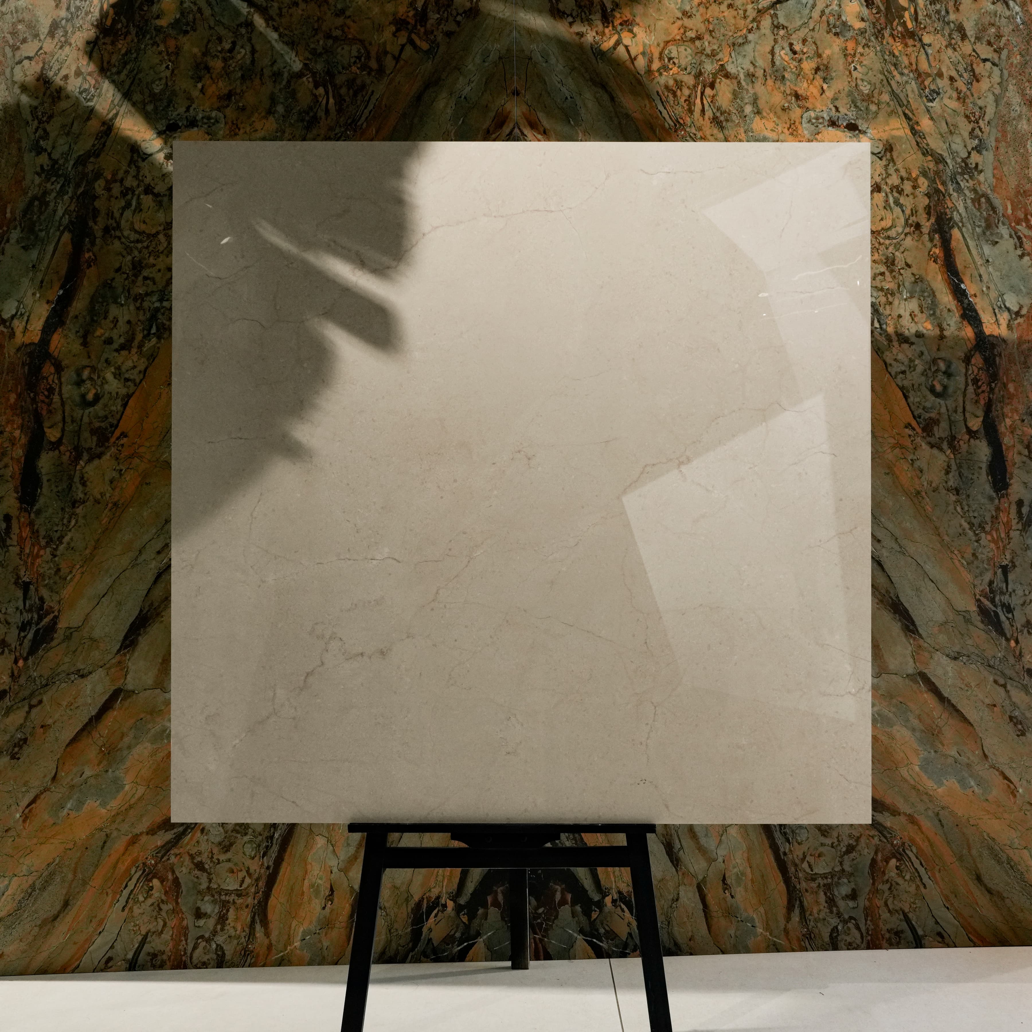 Ultimate Marfil Pro Glossy 120x120 porcelain tile displayed on easel against natural marble backdrop in UAE showroom