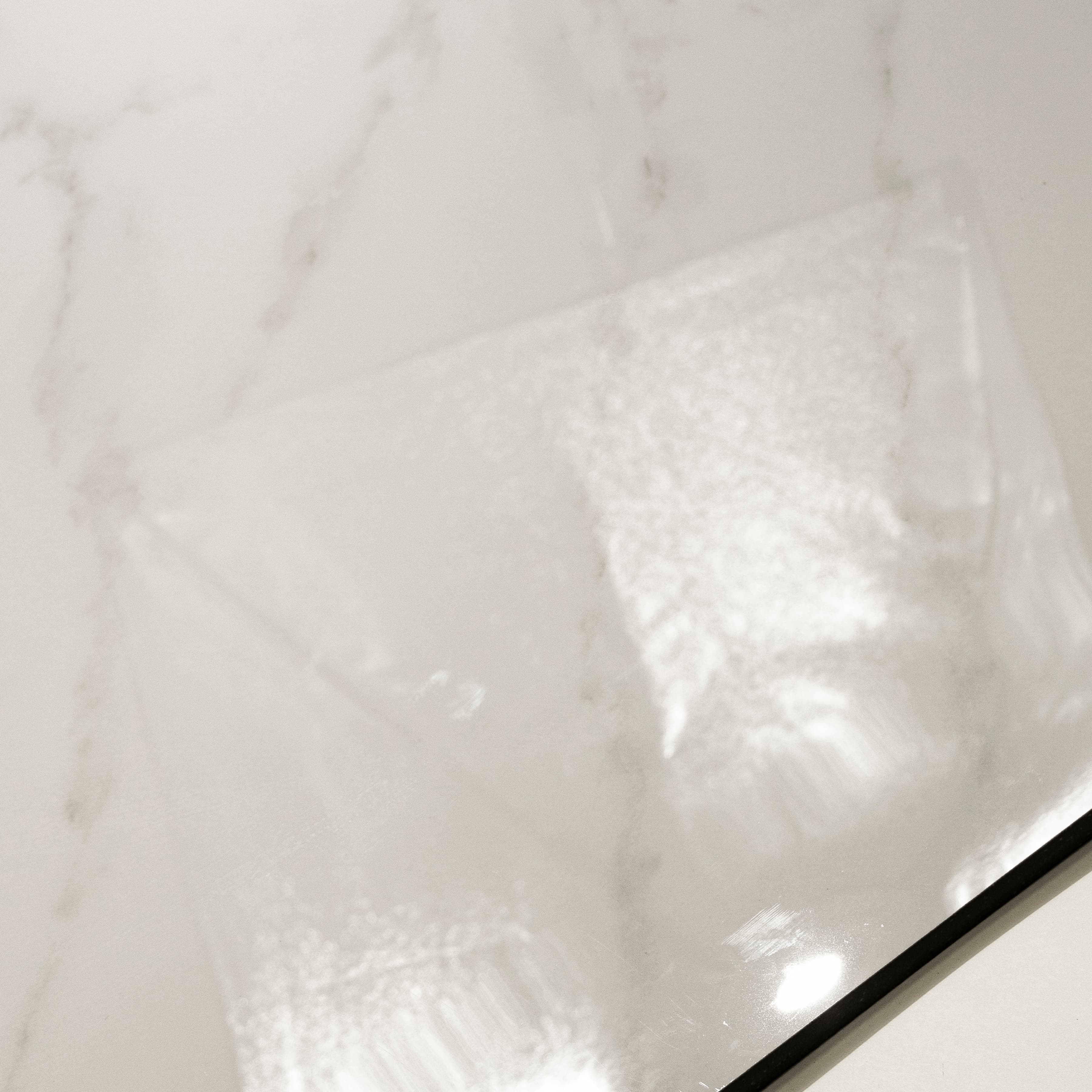 Arena Shine Glossy 120x120 porcelain tile displayed on easel against natural marble backdrop in UAE showroom