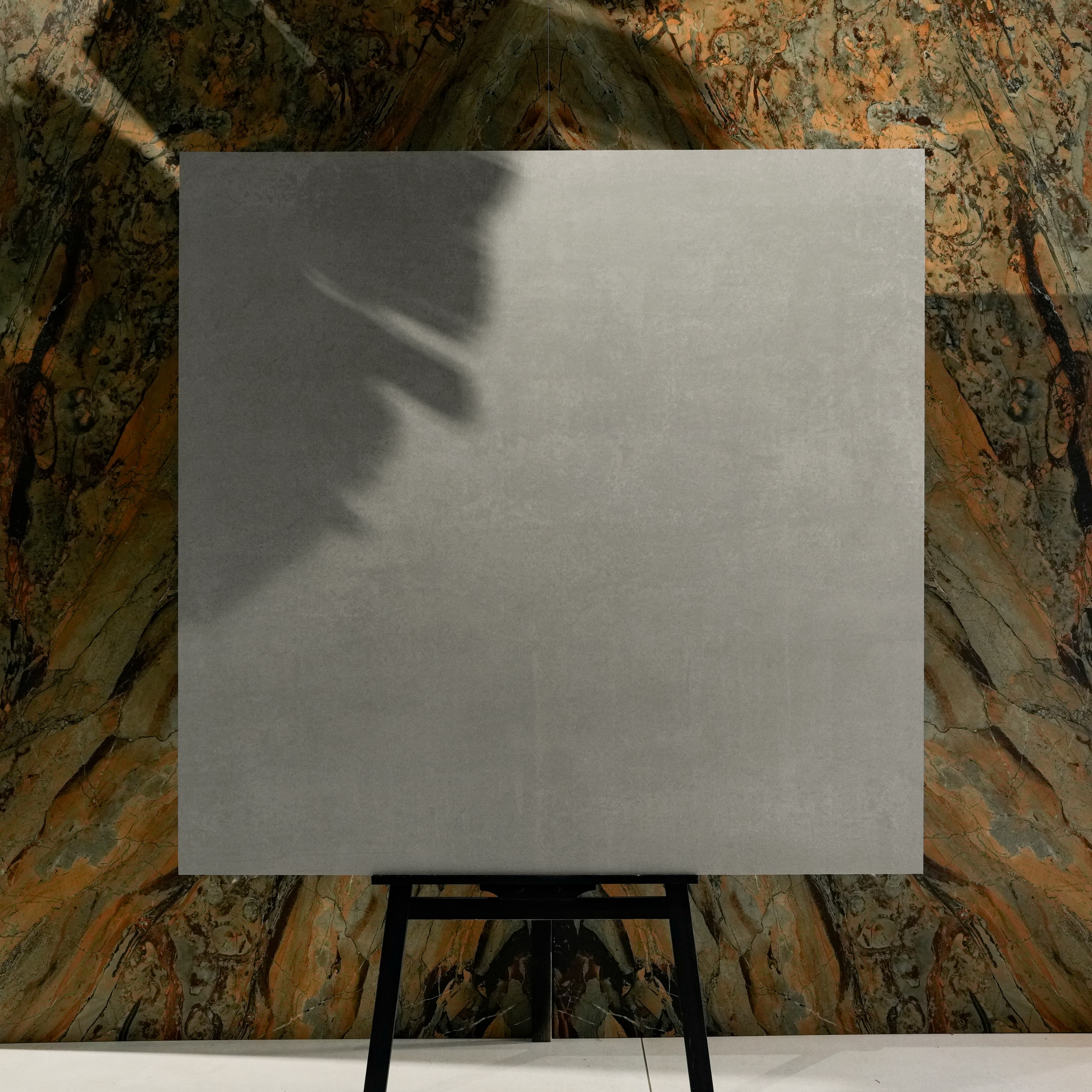 Urban Grey Matt 120x120 porcelain tile displayed on easel against natural marble backdrop in UAE showroom