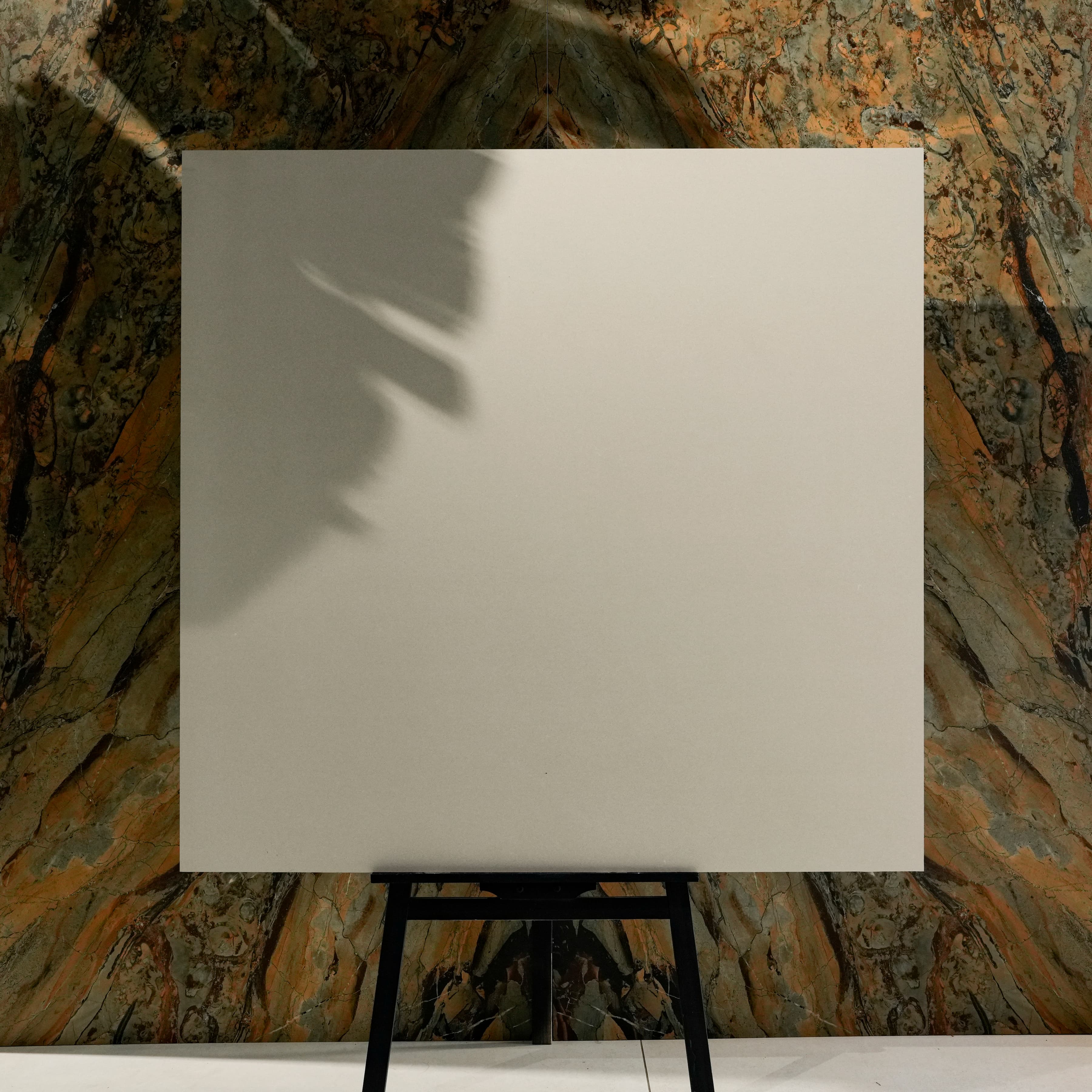Santorini Light 120x120cm matte porcelain tile on easel against onyx marble backdrop in UAE luxury tile showroom