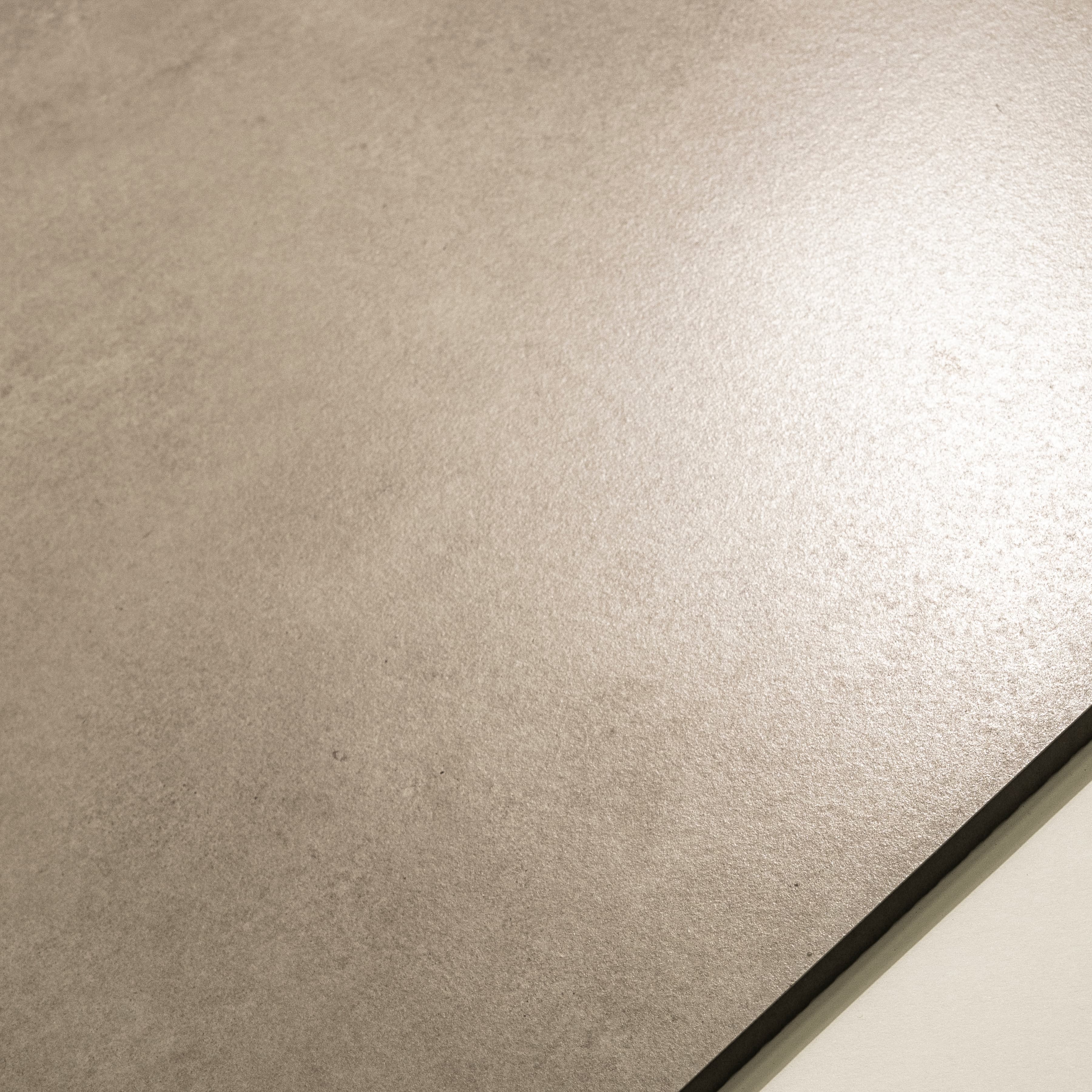 Close-up of Azure Crema Lite matte porcelain surface revealing natural limestone texture in warm sand beige colour
