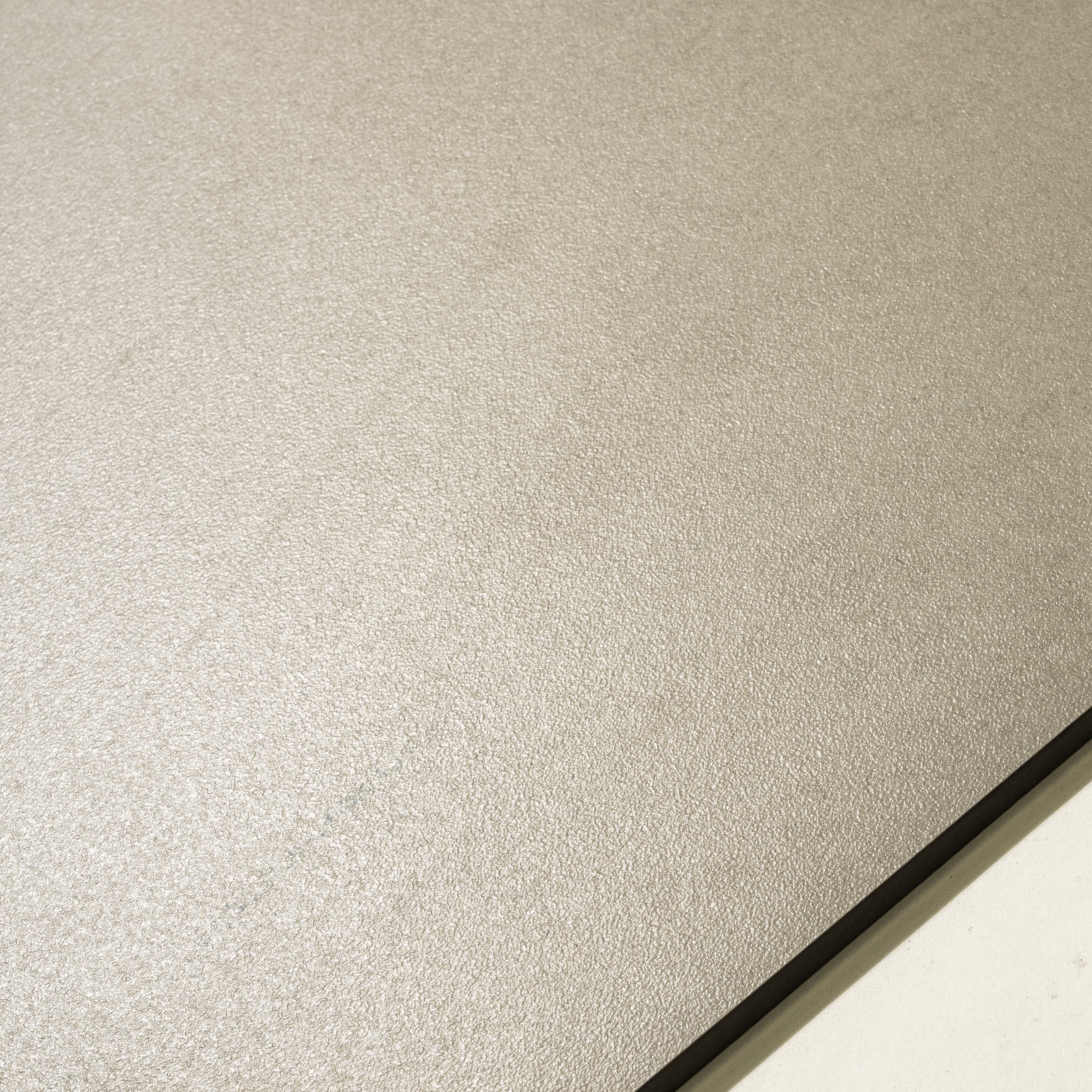 Close-up of Icona Bianco matte porcelain surface showing fine pebbled texture in warm Italian ivory tone