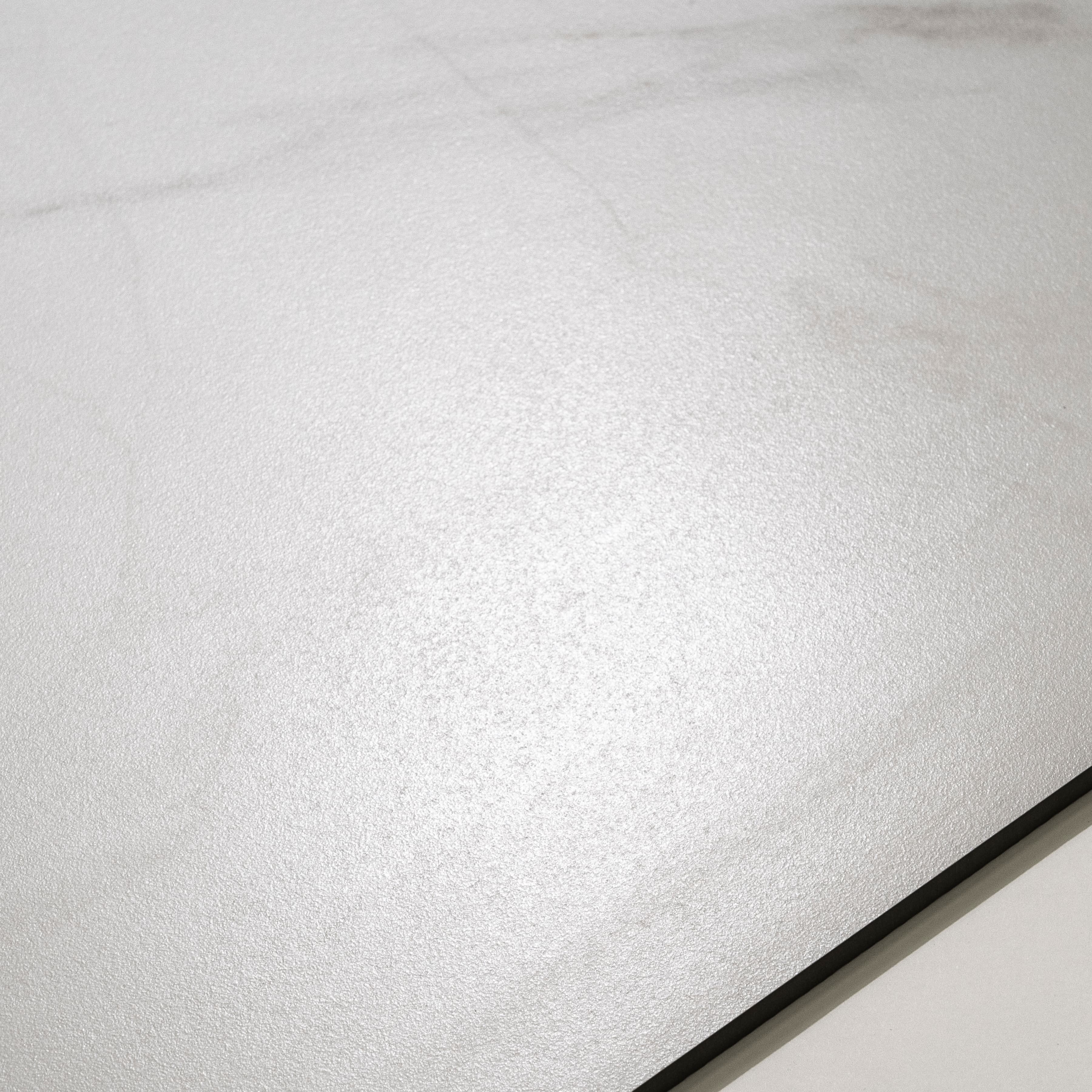 Angled view of Smoke White large format marble look porcelain tile showing diagonal grey veining and rectified edge