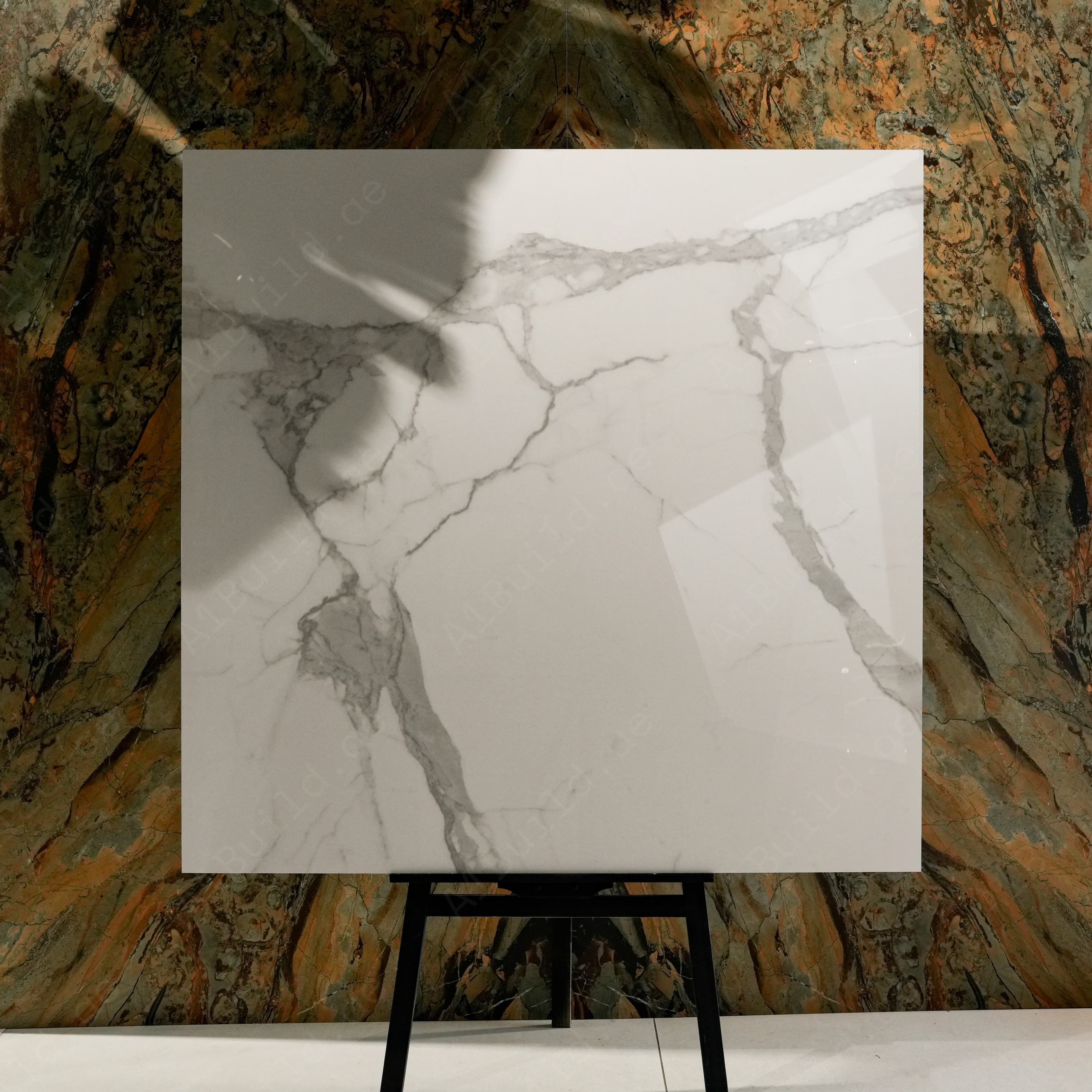 Alps Natural Glossy 120x120 porcelain tile displayed on easel against luxury marble backdrop in UAE showroom