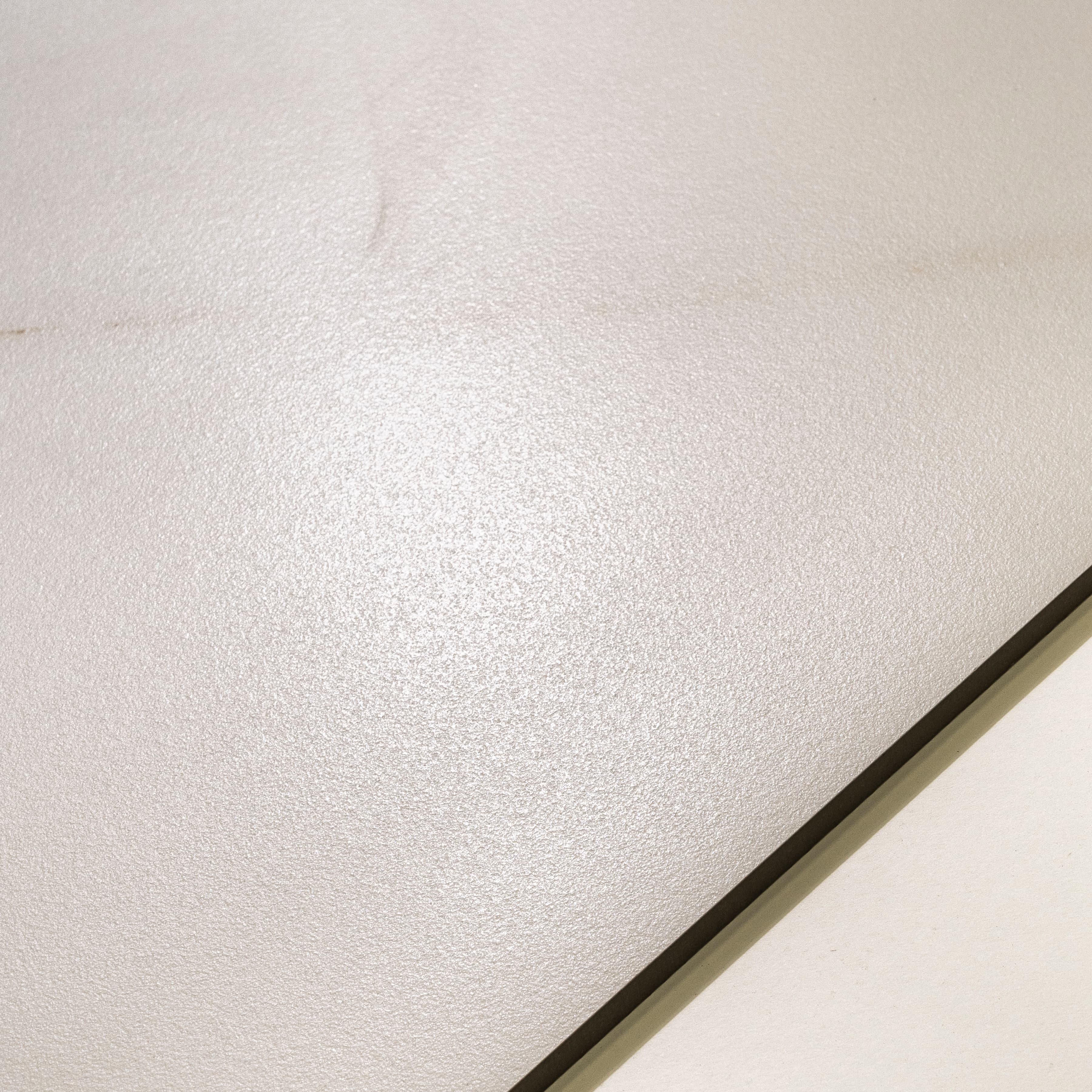 Close-up of Cecelia Gold matte porcelain surface revealing fine refined texture and soft golden marble veining detail