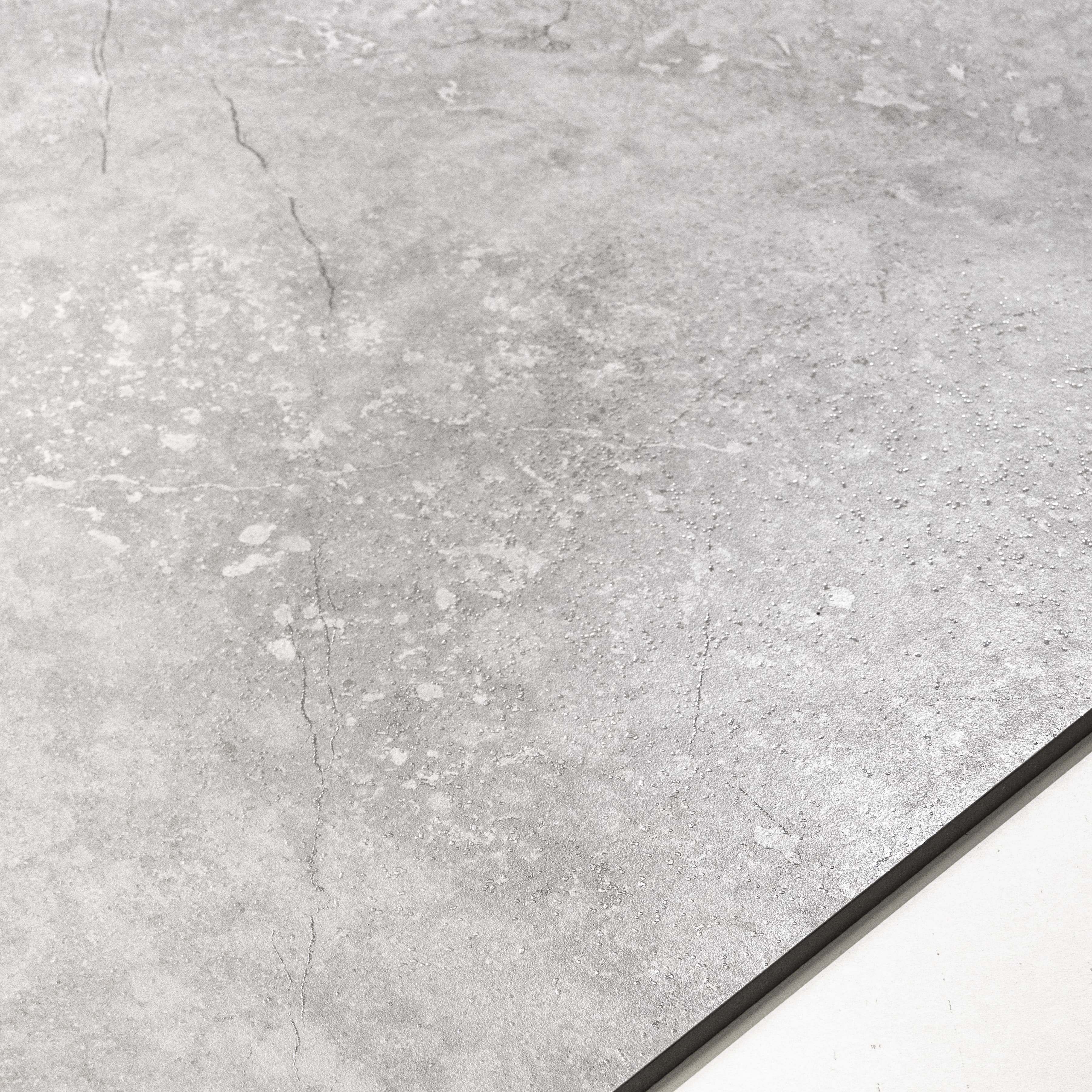 Close-up of Resina Grey matte porcelain surface revealing aged stone patina detail with delicate crack-vein character