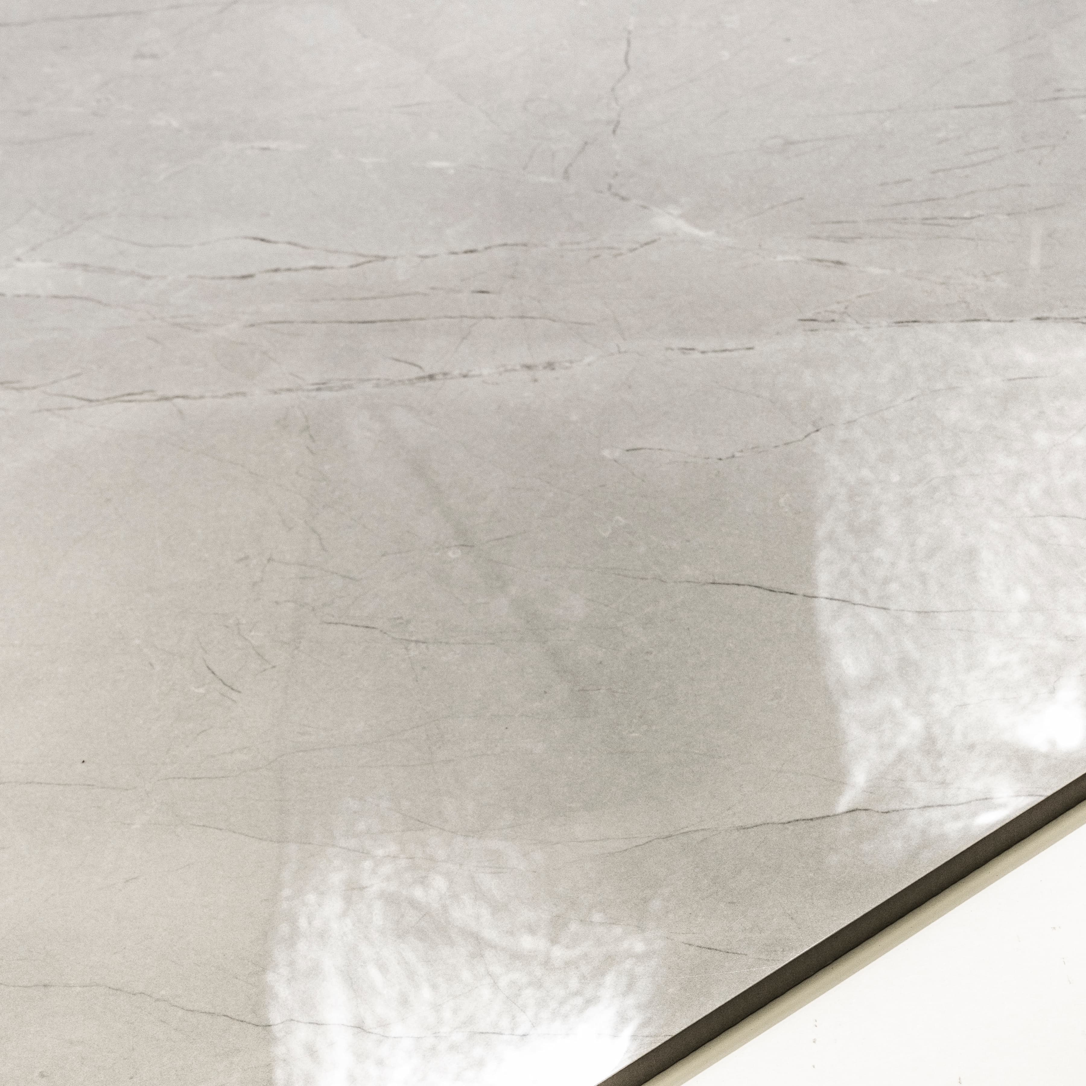 Close-up of Burberry Bianco high-gloss polished porcelain surface revealing delicate hairline marble veining and mirror reflectivity