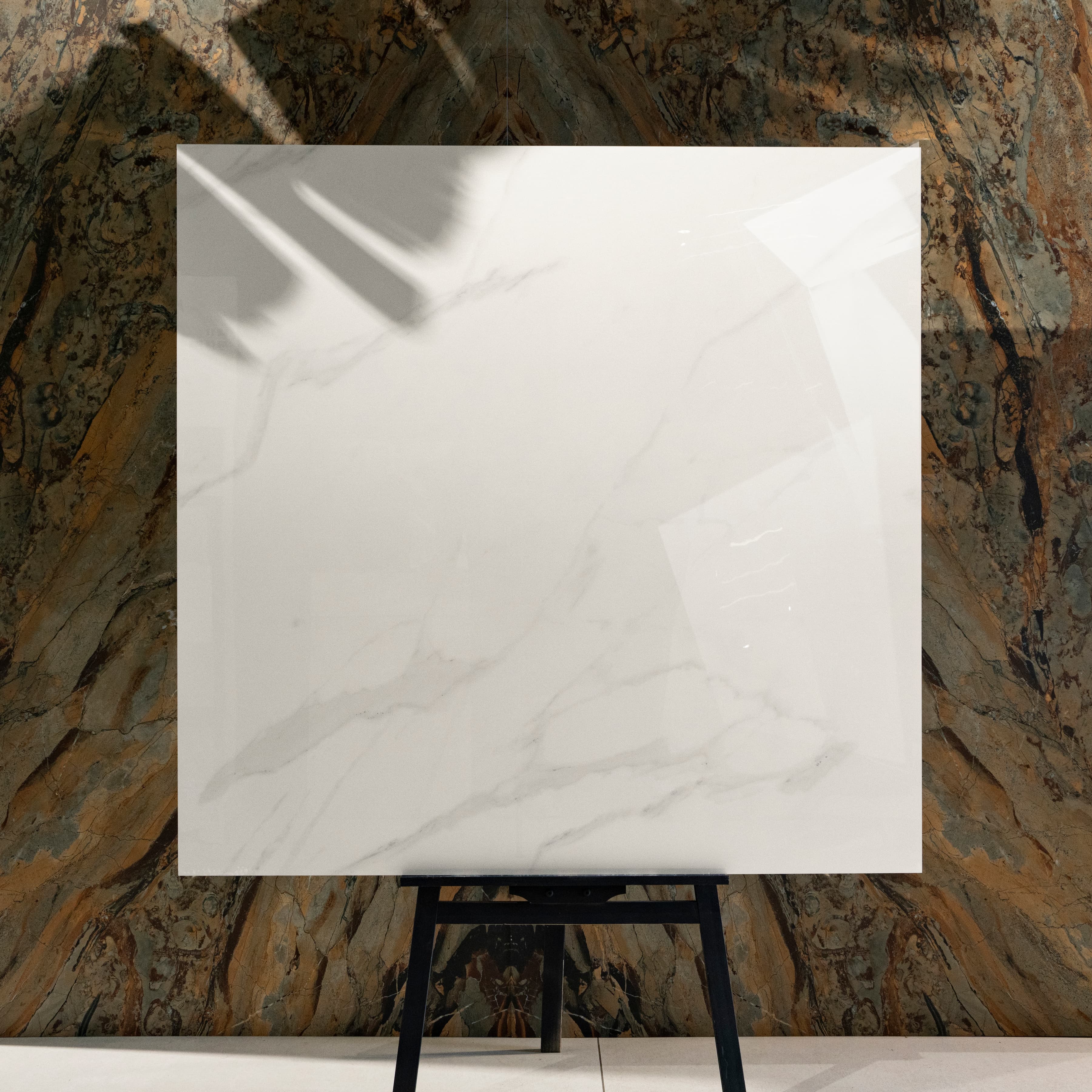 Elite White 120x120cm pure bright white marble look glossy polished porcelain tile on easel against onyx backdrop in UAE luxury tile showroom